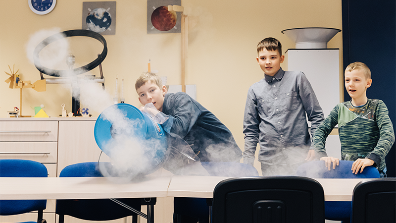 Das Bild enthält eine Gruppe von Kindern mit einem Projektleiter bei einer Bildungsveranstaltung.