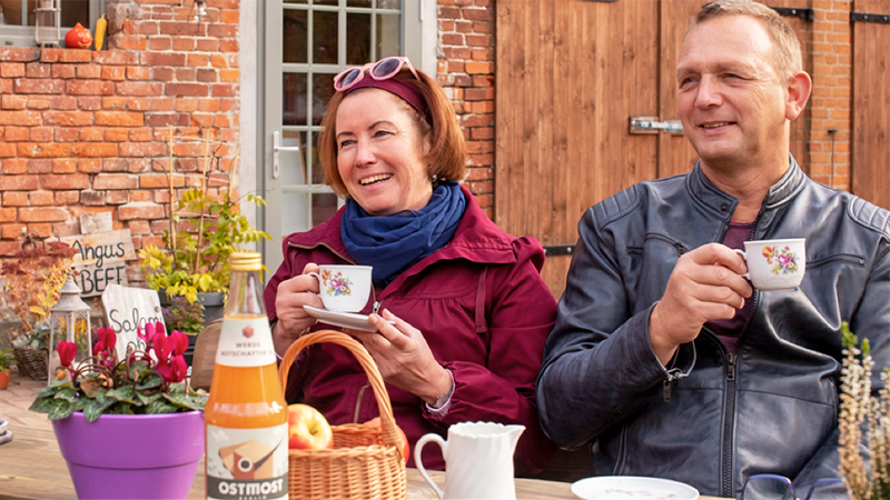 Bild zeigt zwei Personen, die einen Kaffee trinken